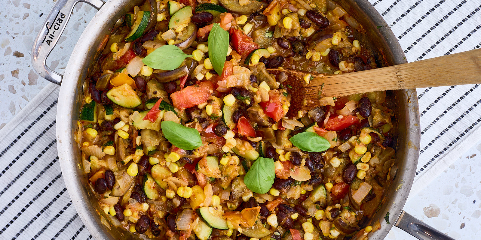 skillet with beans, tomatoes, corn, zucchini and herbs