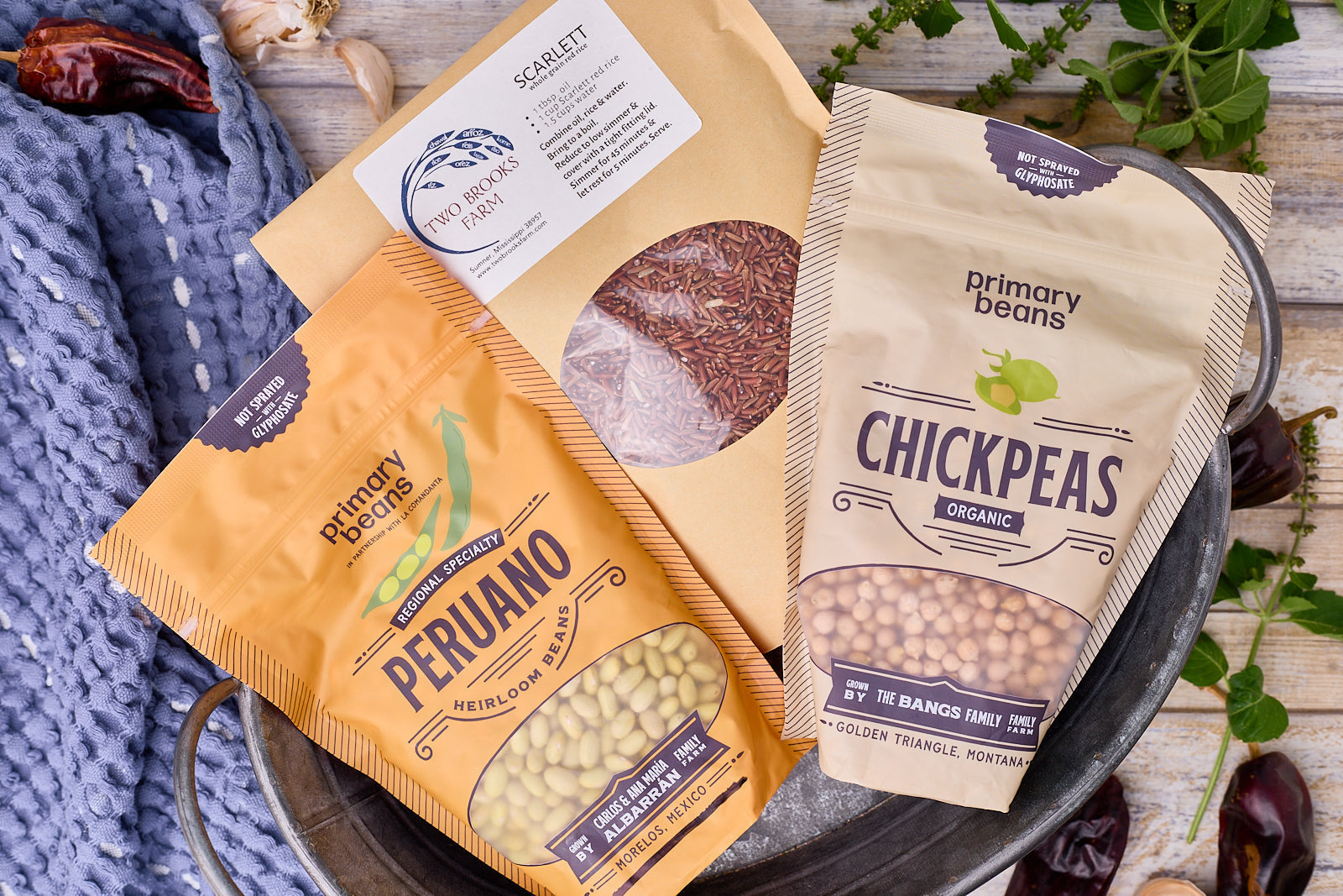 Peruano beans, organic chickpeas and scarlet rice in a decorative rustic bin surrounded by herbs