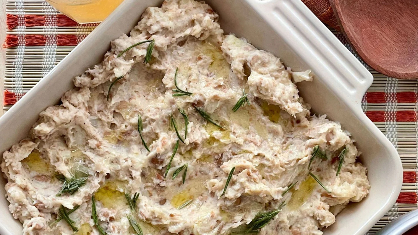 plate of muashed beans topped with rosemary