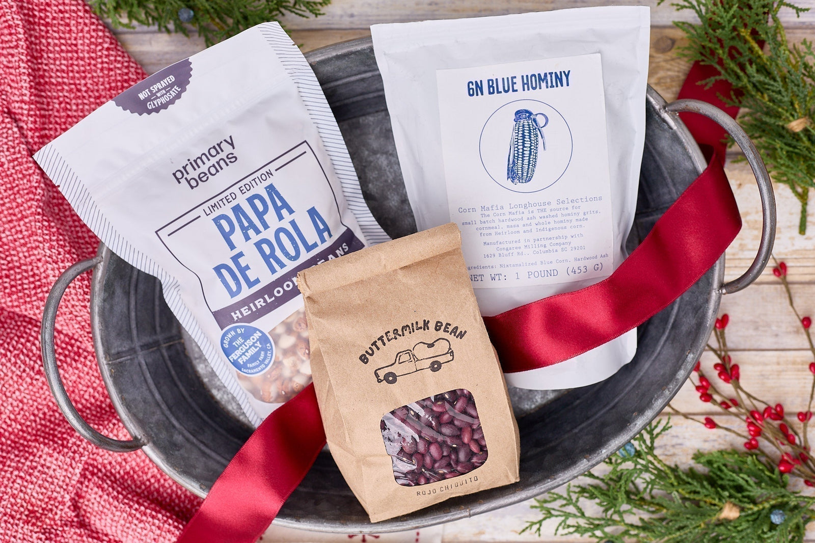 two bags of heirloom beans and one bag of hominy in festive holiday setting