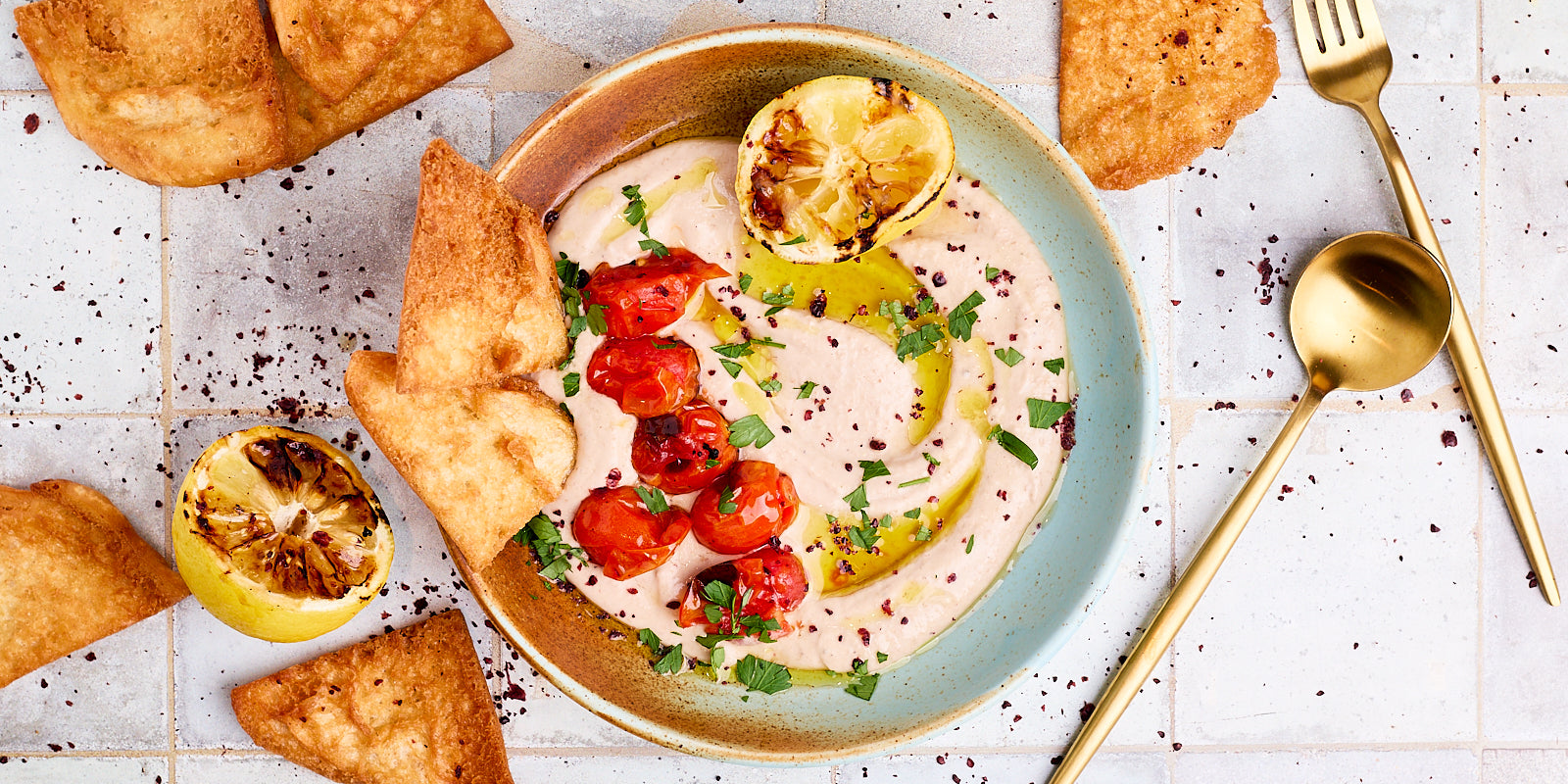 bean dip drizzled with olive oil, herbs and tomatoes