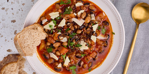 bowl of calypso beans in tomato broth with fried shallots