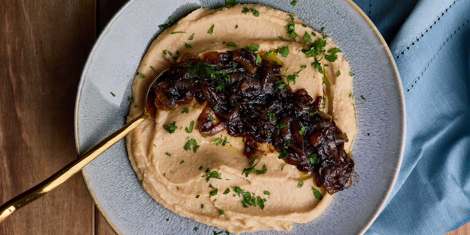 creamy mashed beans topped with dark brown caramelized onions