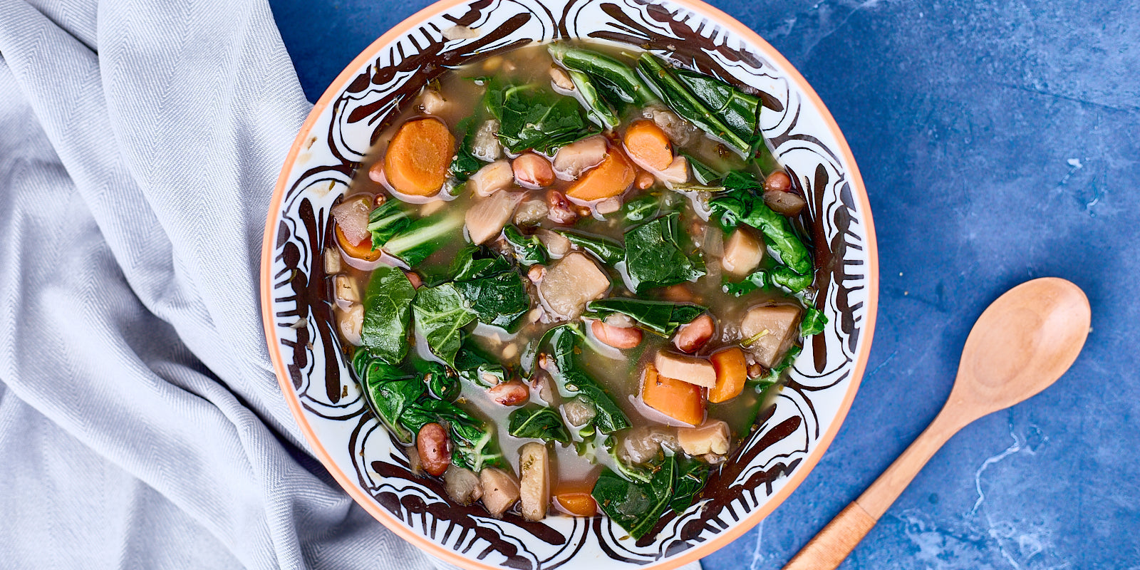 bowl of soup loaded with beans, barley and colorful vegetables