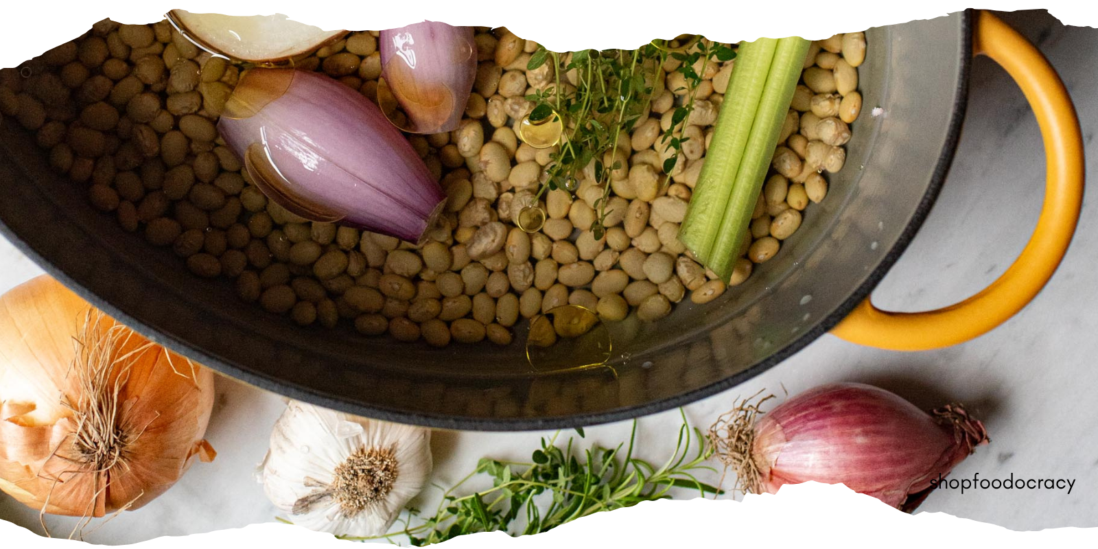 pot of heirloom beans on counter surrounded by veggies and herbs