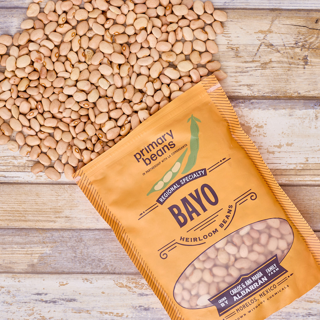 packaged bayo heirloom beans spilling out on wooden surface