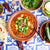 bowl of traditional pozle with cilangro and avocado